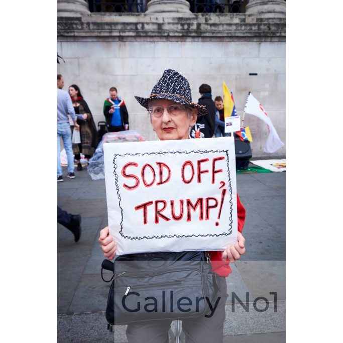 Find a photograph of lovely lady holding a Sod Off Trump placard