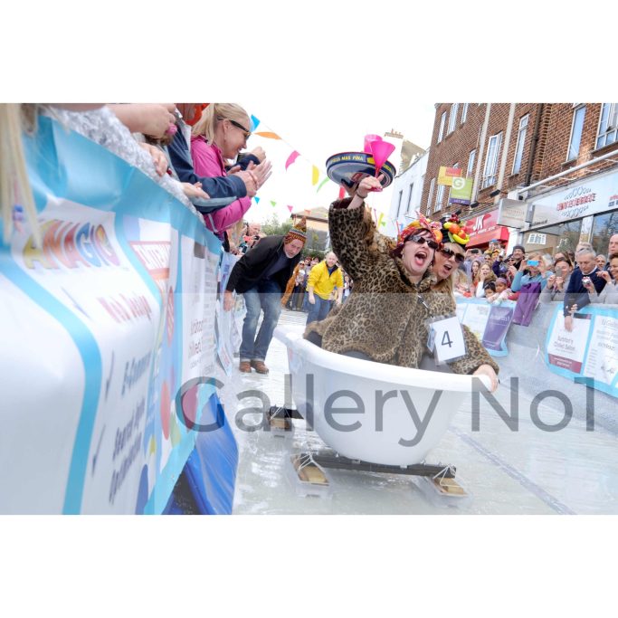 Find a photograph of two women in a bath enjoying ski Sunday in Surbiton