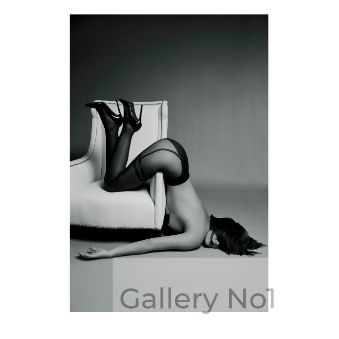 Find photograph of semi naked female draped over a chair