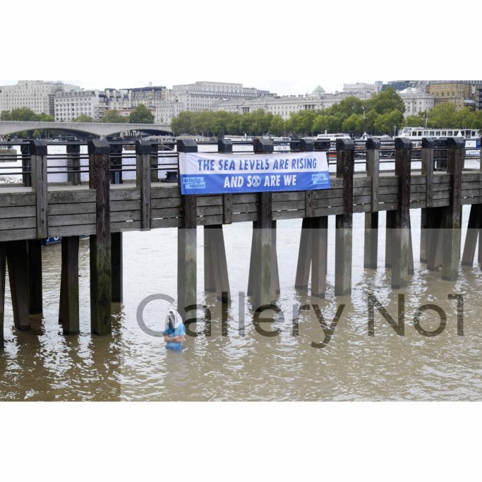 Find a photograph of (Ocean Rebellion) man in water wearing shark head mask